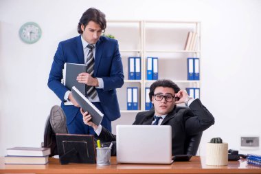 Patron ve erkek asistanı ofiste çalışıyor.