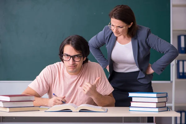 Stará žena učitel a muž student ve třídě — Stock fotografie