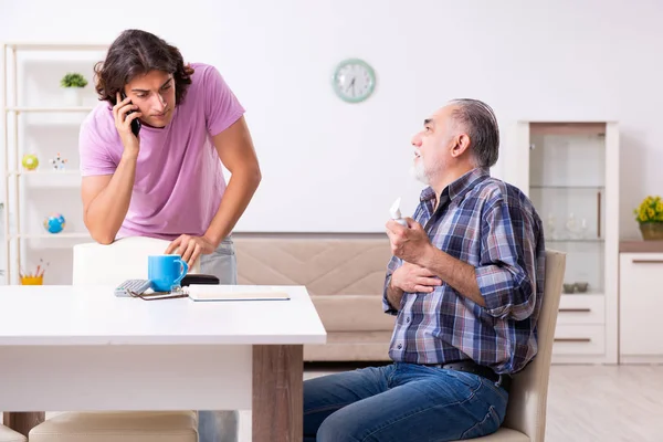 Jonge student en zijn oude opa thuis — Stockfoto