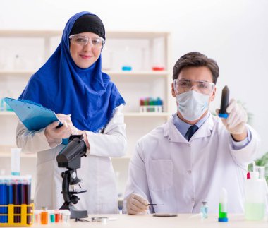 Laboratuvarda çalışan iki kimyager.