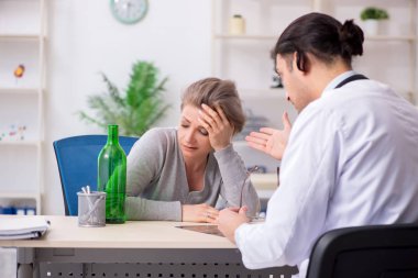 Alkolik kadın, genç erkek doktoru ziyaret ediyor.