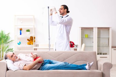 Genç erkek doktor eski hastayı ziyaret ediyor.