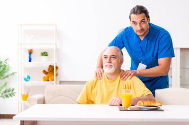 Genç erkek doktor eski hastayı ziyaret ediyor.