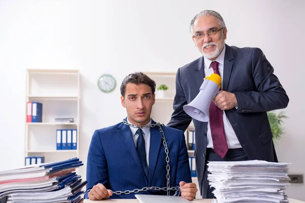 Oude baas en jonge mannelijke werknemer in het kantoor — Stockfoto