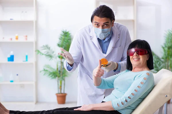 Vecchia visitando giovane medico dentista — Foto Stock