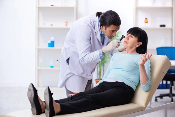 Oude vrouw op bezoek bij jonge arts laryngoloog — Stockfoto