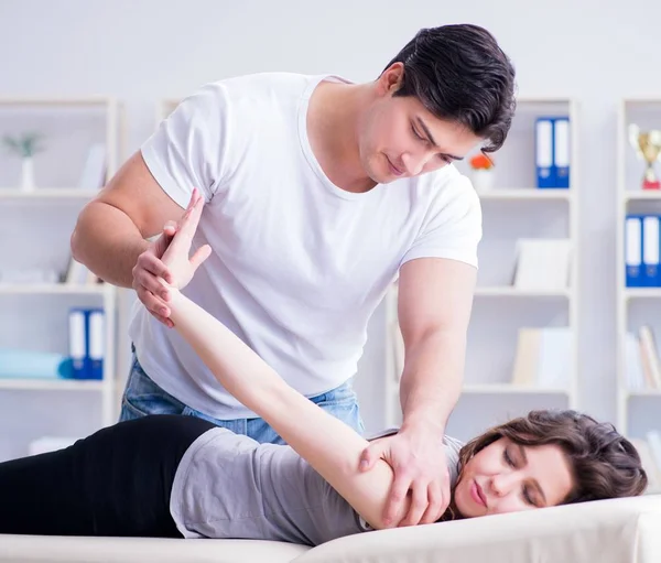 Jonge arts chiropractor masseren vrouwelijke patiënt vrouw — Stockfoto