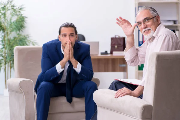 Jongeman op bezoek bij oude mannelijke dokter psycholoog — Stockfoto