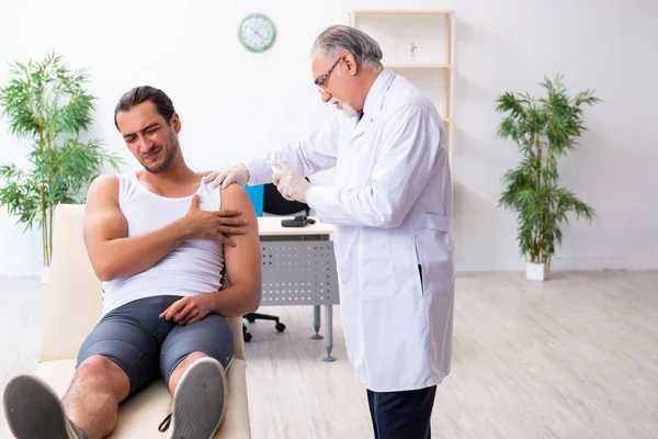 Paciente masculino joven que visita al médico experimentado — Foto de Stock