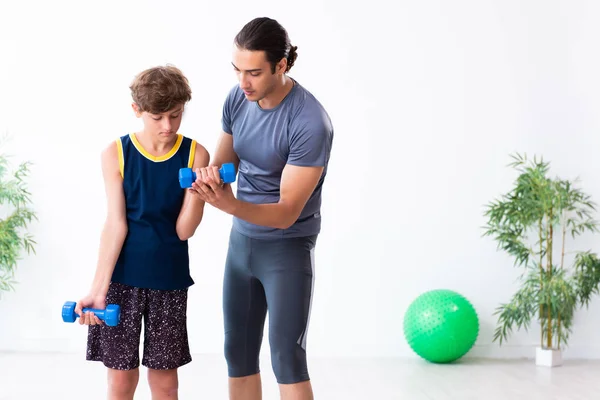 Junger Vater und sein Sohn bei Übungen — Stockfoto