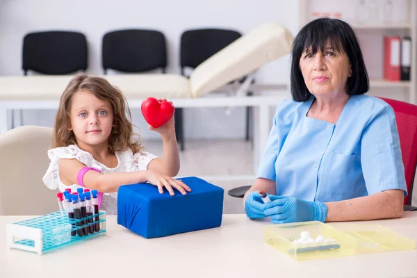 Bambina in visita vecchio medico femminile — Foto Stock