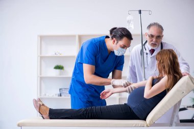 İki doktor genç kadını muayene ediyor.