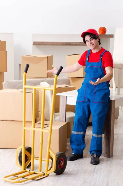 Jovem empreiteiro masculino com caixas trabalhando dentro de casa — Fotografia de Stock