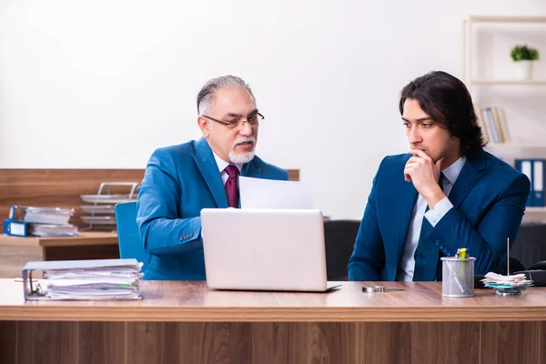 Empregados jovens e velhos trabalhando juntos no escritório — Fotografia de Stock