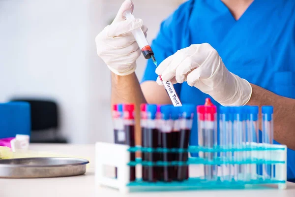 Asistente de laboratorio joven analizando muestras de sangre en el hospital — Foto de Stock