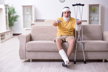 Evde kazadan sonra iyileşen genç adam.