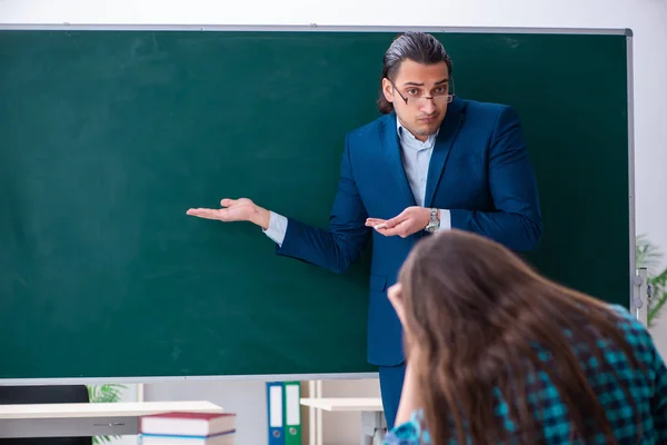 Jonge knappe leraar en vrouwelijke student in de klas — Stockfoto