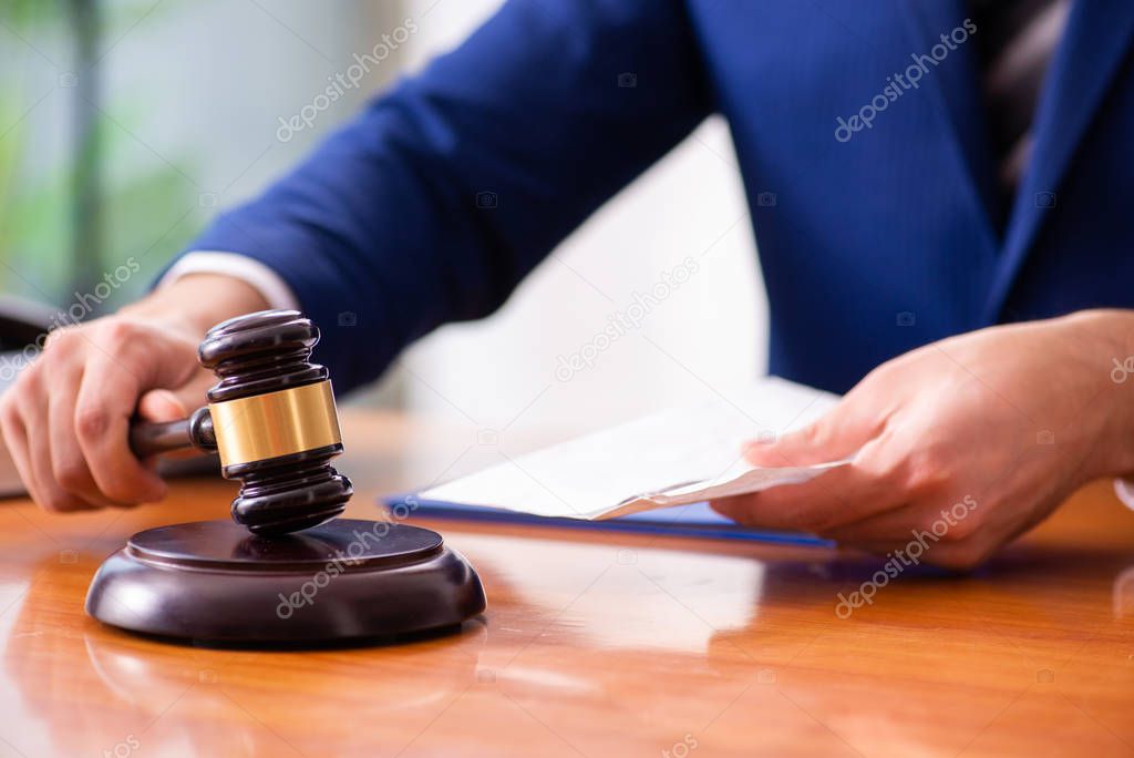 Young male judge sitting in courtroom