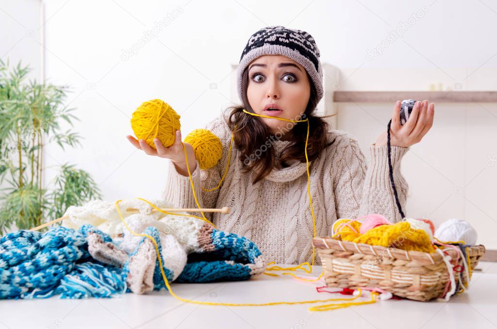 Young beautiful woman knitting at home