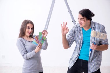 Evde tadilat yapan genç bir aile.