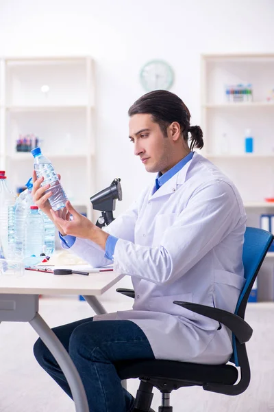 Jovem químico do sexo masculino experimentando em laboratório — Fotografia de Stock