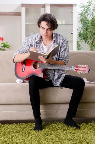 Jongeman met gitaar thuis — Stockfoto