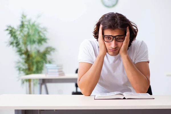 Joven estudiante masculino sentado en el aula — Foto de Stock