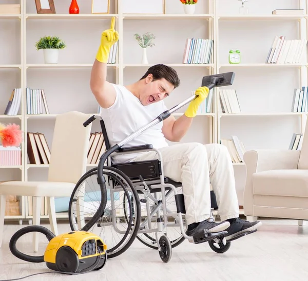 Uomo disabile con aspirapolvere a casa — Foto Stock