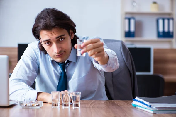 Hombre empleado beber vodka y fumar cigarrillos en el lugar de trabajo — Foto de Stock