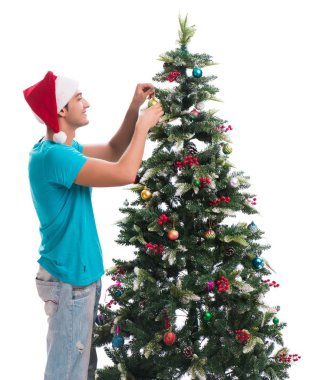 Genç adam beyaz üzerine izole edilmiş noel ağacını süslüyor.