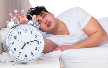 Yatakta uykusuzluk çeken bir adam.