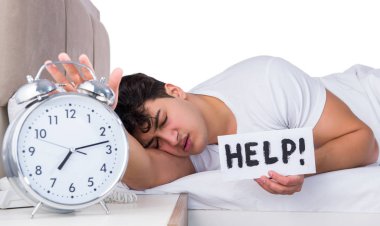 Yatakta uykusuzluk çeken bir adam.