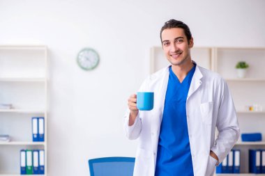 Klinikte çalışan genç erkek doktor.