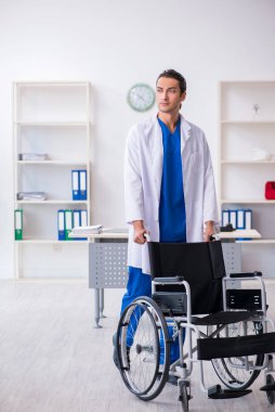 Klinikte çalışan genç erkek doktor.