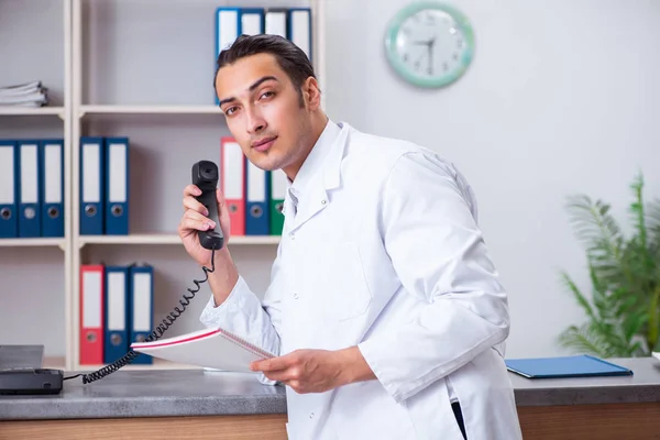 Ung manlig läkare i receptionen på sjukhuset — Stockfoto