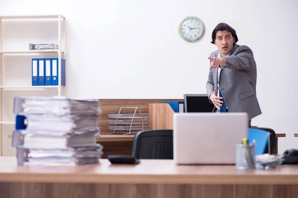 Jonge mannelijke werknemer ongelukkig met overmatig werk — Stockfoto