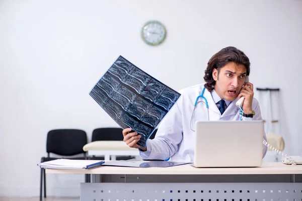 Ung manlig röntgenläkare som arbetar på kliniken — Stockfoto