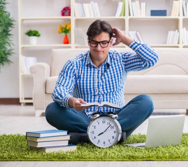 Genç yakışıklı adam evde yerde oturuyor.