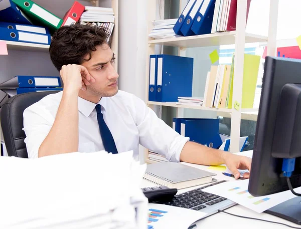 Businessman working in the office with piles of books and papers — Stock Photo, Image