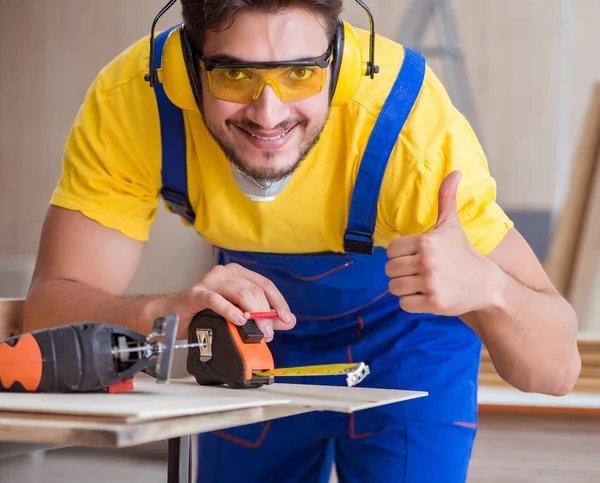 Jonge reparateur timmerman die hout snijdt — Stockfoto