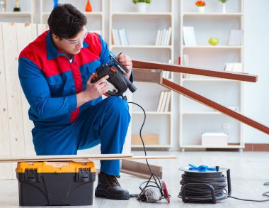 Genç marangoz ahşap kalaslarla çalışıyor.