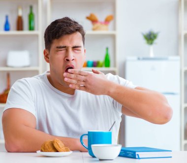 Fazla mesai sonrası kahvaltıda uyuyan bir adam.