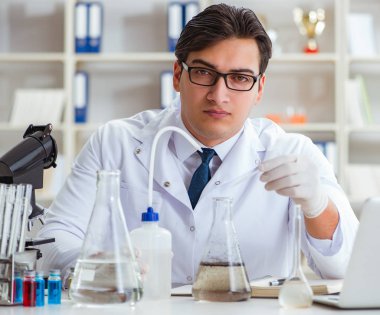 Genç araştırmacı bilim adamı bir su testi kirliliği araştırması yapıyor.
