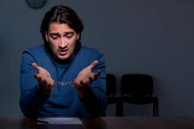 Genç mahkum karanlık odada oturuyor.
