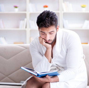 Öğrenci işadamı genç adam bir kitap okuyor.