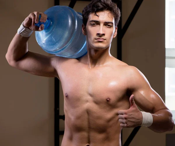 Svalnatý roztržený muž s velkou lahví vody — Stock fotografie