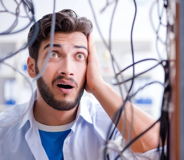 Electrician trying to untangle wires in repair concept — Stock Photo, Image
