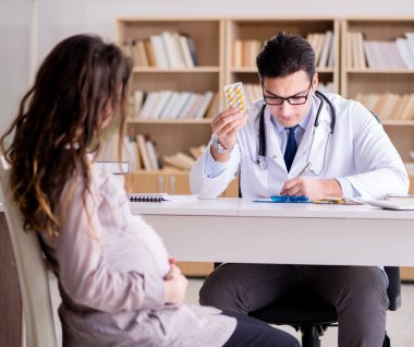 Hamile kadın muayene için doktoru ziyaret ediyor.