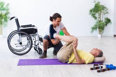 Yaşlı adam içeride egzersiz yapıyor.