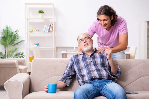 Giovane studente e il suo vecchio nonno a casa — Foto Stock